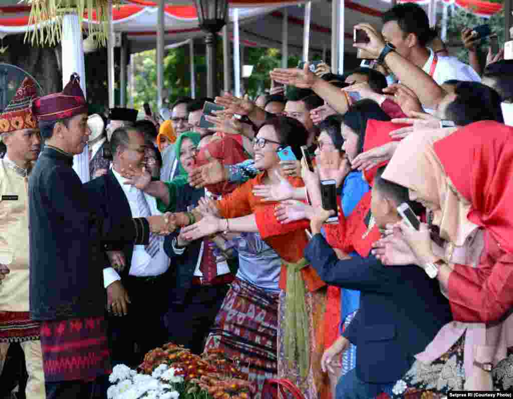 Presiden Joko Widodo menyalami hadirin yang ikut secara langsung menyaksikan pengibaran bendera di Istana Merdeka Jakarta. Sebagian di antara mereka tidak segan-segan meminta swafoto (selfie) dengan presiden, Jakarta, 17 Agustus 2017. (Courtesy: Setpres RI)