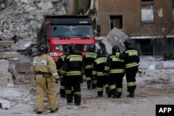 Firefighters are seen at the site of a gas explosion that rocked a residential building in Magnitogorsk, Russia, Jan. 2, 2019.