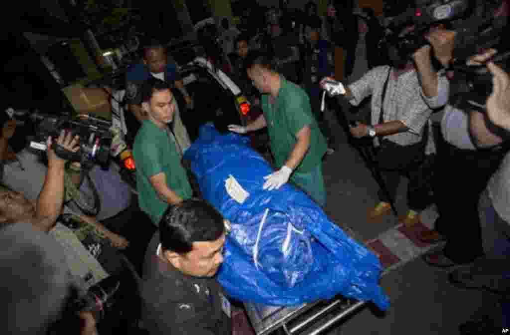 The body of slain British tourist, David Miller, wrapped in plastic sheet, is carried at a forensic police facility in Bangkok, Thailand, Tuesday, Sept. 16, 2014. Police on the scenic resort island of Koh Tao in southern Thailand conducted a sweep of hotels and workers' residences Tuesday searching for clues into the slayings of two British tourists whose nearly naked, battered bodies were found on a beach a day earlier.(AP Photo/Sakchai Lalit)