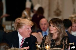 President Donald Trump and first lady Melania Trump talk while having Thanksgiving Day dinner at their Mar-a-Lago estate in Palm Beach, Fla., Nov. 22, 2018.