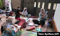 Inggit Andini (kanan) mengajar anak-anak yang tidak punya akses internet di rumahnya, di Tangerang, 10 Agustus 2020.