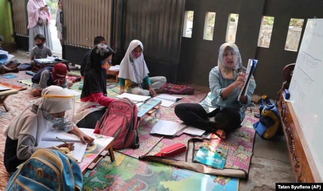 Inggit Andini (kanan) mengajar anak-anak yang tidak punya akses internet di rumahnya, di Tangerang, 10 Agustus 2020.