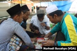 Pengungsi menikmati makan siang di Pemenang, Lombok Utara.