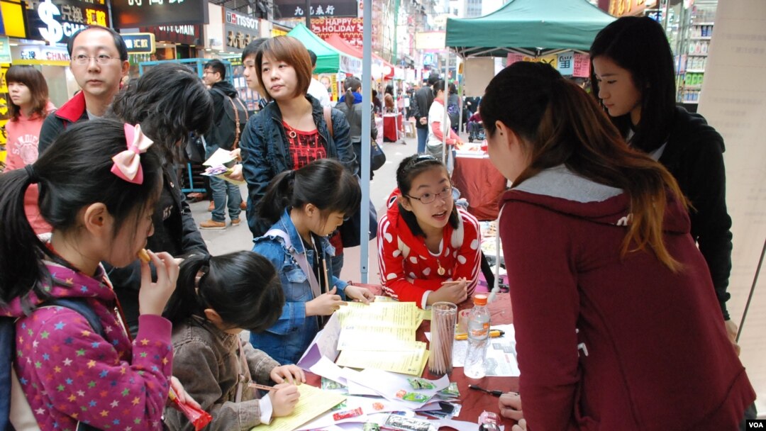 有家長帶同年幼子女參觀中國維權律師關注組的攤位,了解中國維權律師子女被當局剝奪人權的狀況 (美國之音湯惠芸)