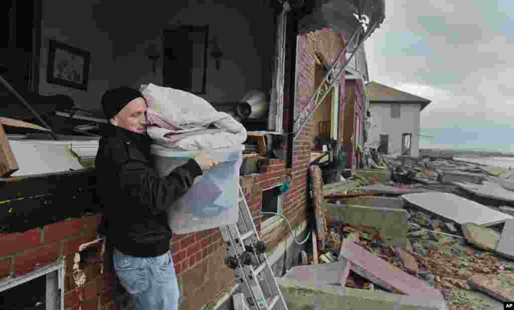 Peter Andrews removes belongings from his father's beachfront home, destroyed in the aftermath of a storm surge from superstorm Sandy, Oct. 30, 2012, in Coney Island's Sea Gate community in New York.