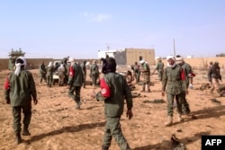 FILE - Soldiers attend to wounded and casualties in the aftermath of a suicide bomb attack who ripped through a camp grouping former rebels and pro-government militia in troubled northern Mali left 40 people dead on Jan. 18, 2017 in Gao.