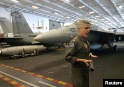 Strike Group Commander Rear Admiral Steve Koehler gestures while talking to journalists and Philippine officials in front of F-18 fighters at the hangar bay of the USS Theodore Roosevelt, transiting the South China Sea, April 10, 2018.