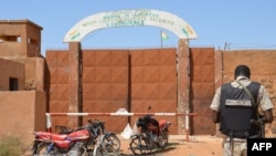 Un gendarme nigérien se tient près des motocyclettes calcinées utilisées par les assaillants, devant la prison de Koutoukale, près de Niamey, suite à une attaque le 17 octobre 2016.