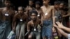 Migrants, who were found at sea on a boat, line up at Mee Tike temporary refugee camp near Bangladesh border fence, at Kanyin Chaung jetty outside Maungdaw township, northern Rakhine state, Myanmar, June 4, 2015