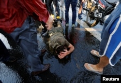 FILE - A soldier protects himself from the mob after troops involved in the coup attempt surrendered on the Bosphorus Bridge in Istanbul, Turkey, July 16, 2016.