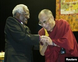 FILE - The Dalai Lama (R) greets South African Archbishop Desmond Tutu in Vancouver, British Columbia, Apr. 18, 2004.