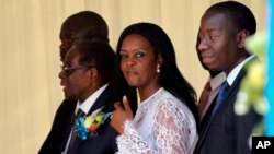 Zimbabwean First Lady Grace Mugabe, center, walks with Zimbabwean President Robert Mugabe at a ceremony to rename Harare International airport to Robert Gabriel Mugabe International Airport in Harare, Thursday, Nov. 9, 2017. 