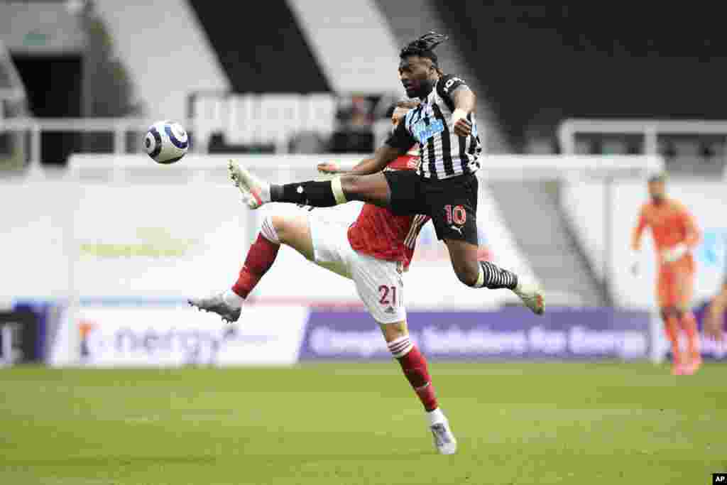 Newcastle&#39;s Allan Saint-Maximin, 10, competes for the ball with Arsenal&#39;s Calum Chambers during the English Premier League soccer match between Newcastle United and Arsenal at St James&#39; Park stadium, in Newcastle, England.