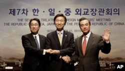 From right, Chinese Foreign Minister Wang Yi, South Korean Foreign Minister Yun Byung-se and Japanese Foreign Minister Fumio Kishida pose during the seventh trilateral foreign ministers' meeting in Seoul, South Korea, March 21, 2015. 