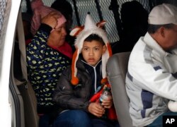 FILE - A migrant family waits with others before being transported by Mexican authorities to the San Ysidro port of entry to begin the process of applying for asylum in the United States in Tijuana, Mexico, Jan. 29, 2019.