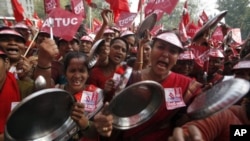 Demonstrators shout slogans as they hold steel plates during a protest against food prices in New Delhi, Feb. 23, 2011.