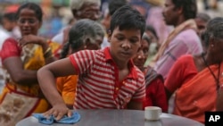 A boy cleans a table while working at an eatery in Hyderabad, India, June 11, 2016. A UNICEF report based on census data says the proportion of child workers in the 5-to-9-year age group jumped to 24.8 percent in 2011 from 14.6 percent in 2001.
