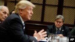 FILE - White House Chief Strategist Steve Bannon listens at right as President Donald Trump speaks during a meeting on cyber security in the Roosevelt Room of the White House in Washington.