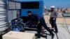 Teknisi Palestina Raed Nakhal dari Dana Bantuan Anak-Anak Palestina (kanan) dan Abdullah Dewik, memeriksa generator yang menyuplai air bersih, GEN-M, 30 April 2020. (Foto: AP)