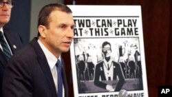 FILE - Raymond Duda, special agent in charge in Seattle, speaks as he stands next to a poster that was mailed earlier in the year to the home of an investigative reporter, during a news conference in Seattle, Feb. 26, 2020. 