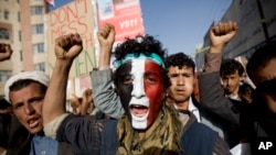 FILE - A Houthi Shi'ite rebel with Yemen's flag painted on his face chants slogans during a rally in the capital, Sana'a, Yemen.