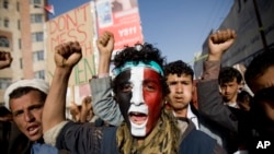 Seorang pemberontak Syiah Houthi dengan lukisan bendera Yaman di wajahnya meneriakkan slogan-slogan dalam protes di Sana'a, 27 Februari 2015. (AP/Hani Mohammed)