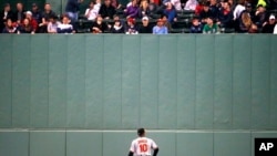 Baltimore Orioles' Adam Jones looks up at fans in center field during the third inning of a baseball game against the Boston Red Sox, May 2, 2017, in Boston.