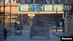FILE - Russian soldiers in armored vehicles patrol a street in Aleppo, Syria, Feb. 2, 2017.