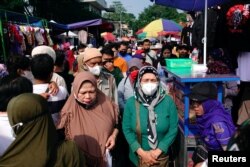 Sejumlah perempuan mengenakan masker pelindung berbelanja di pasar jalan Gasibu di tengah pandemi COVID-19 di Bandung, Jawa Barat, 31 Oktober 2021. (Foto: Reuters)