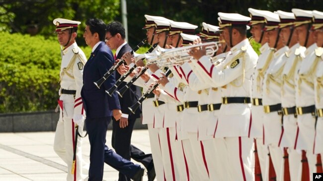 日本首相安倍晋三（中）、防卫大臣河野太郎（右）在东京准备检阅仪仗队。（2019年9月17日）