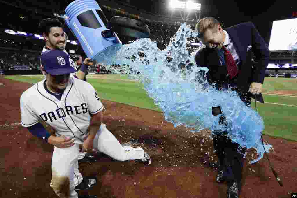 San Diego Padres' Hunter Renfroe, left, dodges energy drink dumped by teammate Austin Hedges after hitting a walk-off home run during the tenth inning of a baseball game against the Milwaukee Brewers in San Diego, California, May 15, 2017.