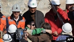 Thợ mỏ Edison Pena (giữa) ôm người vợ sau khi được giải cứu từ mỏ than San Jose, ngày 13/10/2010