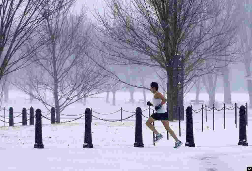 An man runs on the National Mall as snow falls in Washington, D.C. The snow forced area schools and the U.S. federal government offices to close on Monday.