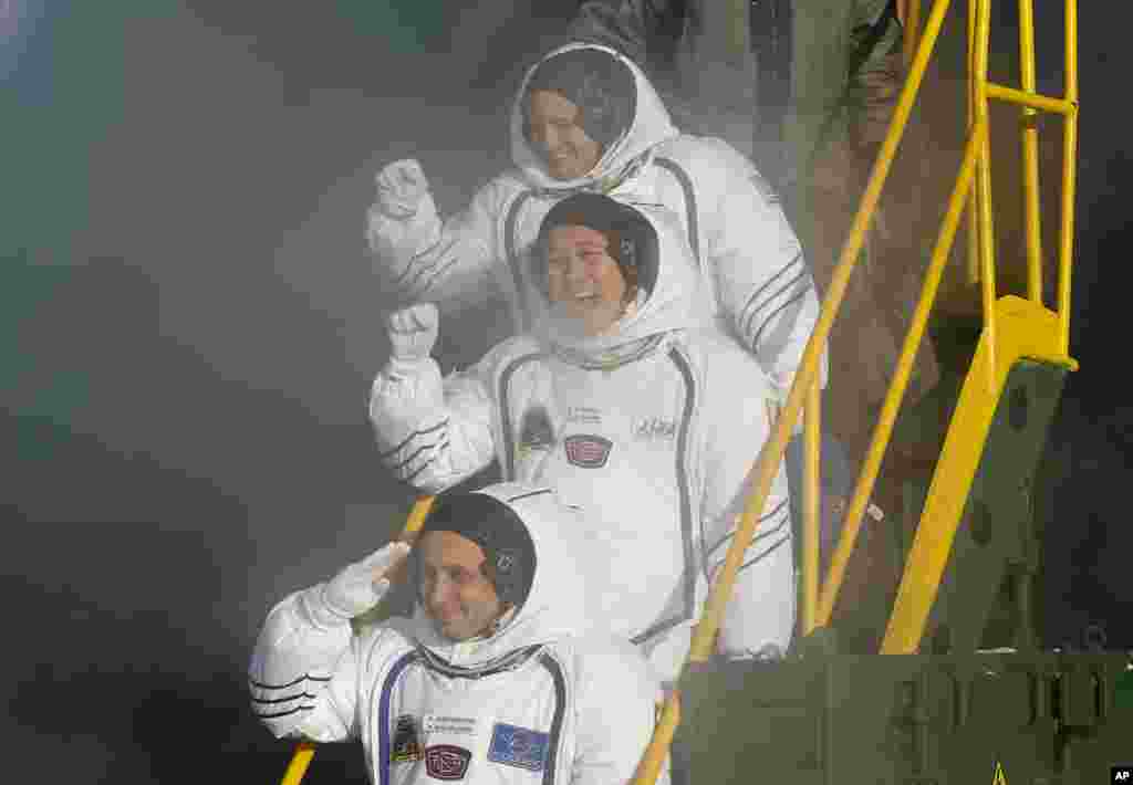 Russian cosmonaut Anton Shkaplerov, U.S. astronaut Scott Tingle, and Japanese astronaut Norishige Kanai, crew members of the mission to the International Space Station, ISS, wave near the rocket prior to the launch of the Soyuz-FG rocket.