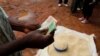 FILE - A trader counts money as he sells maize near the capital Lilongwe, Malawi, Feb. 1, 2016. A report indicates Malawi's foreign exchange reserves in the first quarter of 2022 sharply dropped compared to the fourth quarter of 2021.