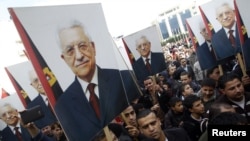 Palestinians hold placards of President Mahmoud Abbas during a rally in support of his efforts to secure a diplomatic upgrade at the United Nations, Ramallah, West Bank, November 25, 2012.