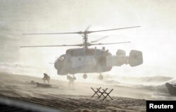 FILE - Servicemen take part in the joint war games Zapad-2013 (West-2013), at the Khmelevka range on Russia's Baltic Sea in the Kaliningrad Region, Sept. 26, 2013.