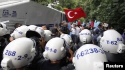 Turkish riot police try to stop ethnic Uighurs from marching to the Chinese Consulate during a protest against China, in Istanbul, Turkey, July 21, 2011.