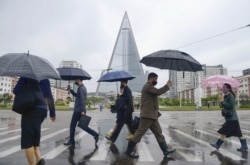 Orang-orang yang memakai masker pelindung berjalan di tengah kekhawatiran atas COVID-19 di Pyongyang, Korea Utara, 15 Mei 2020, dalam foto yang dirilis oleh Kyodo. (Foto: Kyodo via REUTERS)