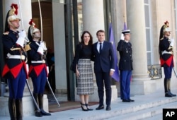 New Zealand Prime Minister Jacinda Ardern, center left, is greeted by French President Emmanuel Macron, center right, as she arrives at the Elysee Palace, in Paris, May 15, 2019.