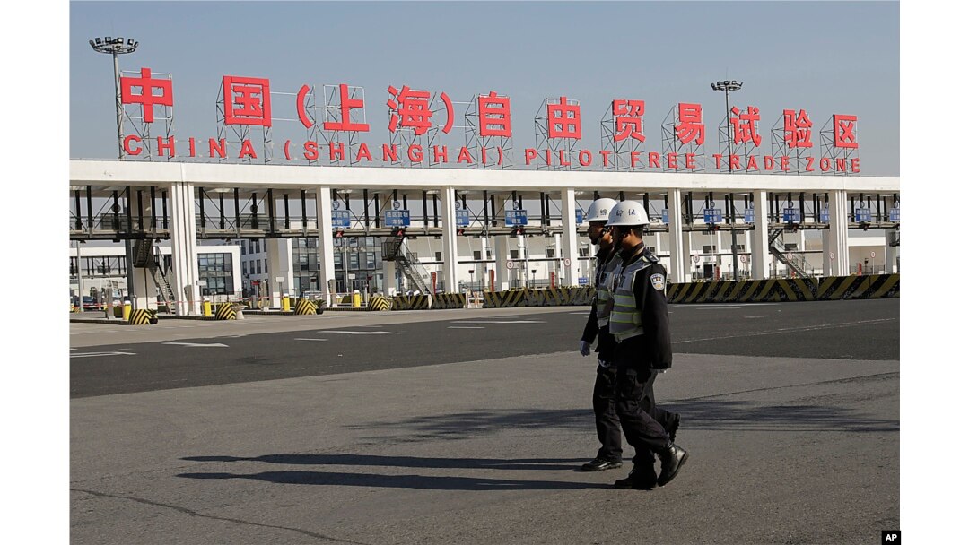 FILE - Security guards patrol the main gate of the China (Shanghai) Pilot Free Trade Zone at the Pudong International Airport in Shanghai, China.