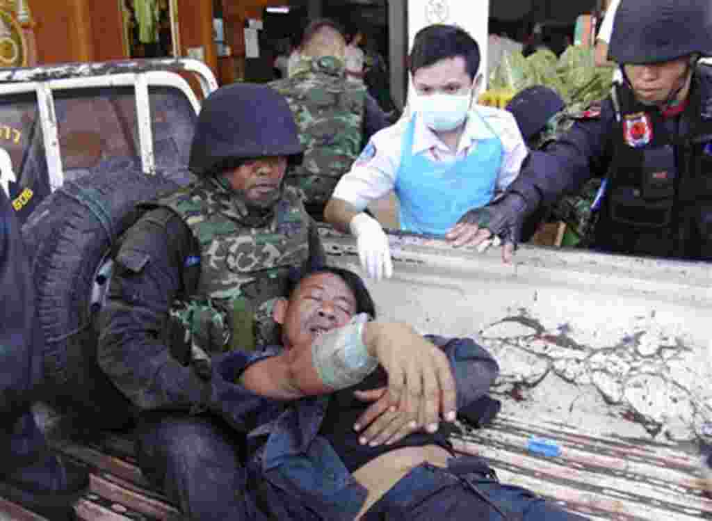A Thai soldier injured in a fighting with Cambodia is helped by his comrades and a nurse after arriving at a hospital in Phnom Dongrak district of Surin province, northeastern Thailand, April 22, 2011