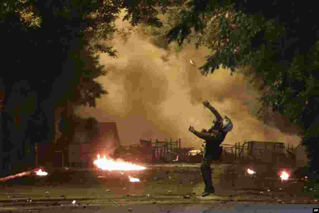 A riot policeman throws a stun grenade during clashes outside the Polytechnic University in Athens, Greece, Nov. 17, 2018, on the 45th anniversary of a student uprising against the country&#39;s then-ruling military regime.