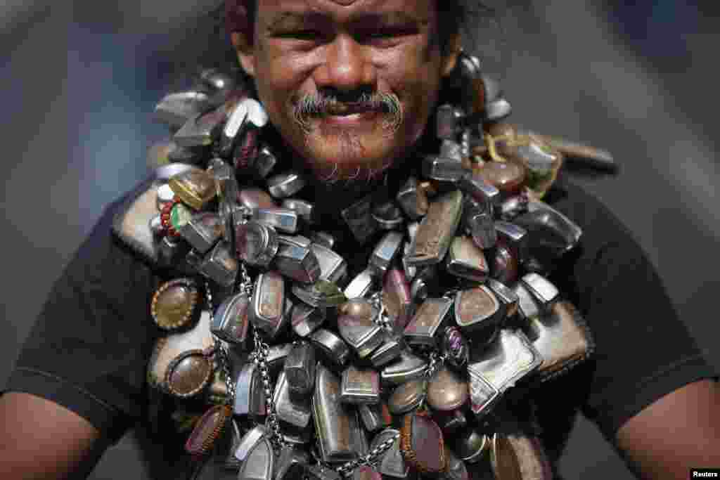 A protester wears a chain with many amulets as he joins others in a march towards central Bangkok, Thailand. Thousands of people took to the streets of the Thai capital after lawmakers approved a draft political amnesty bill that could allow the return of self-exiled former premier Thaksin Shinawatra.