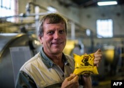 FILE: Former president of the Commercial Farmers Union (CFU) Deon Theron holds a packet of sour milk (maas) in his milk processing factory on November 27, 2017 in Beatrice, Zimbabwe.