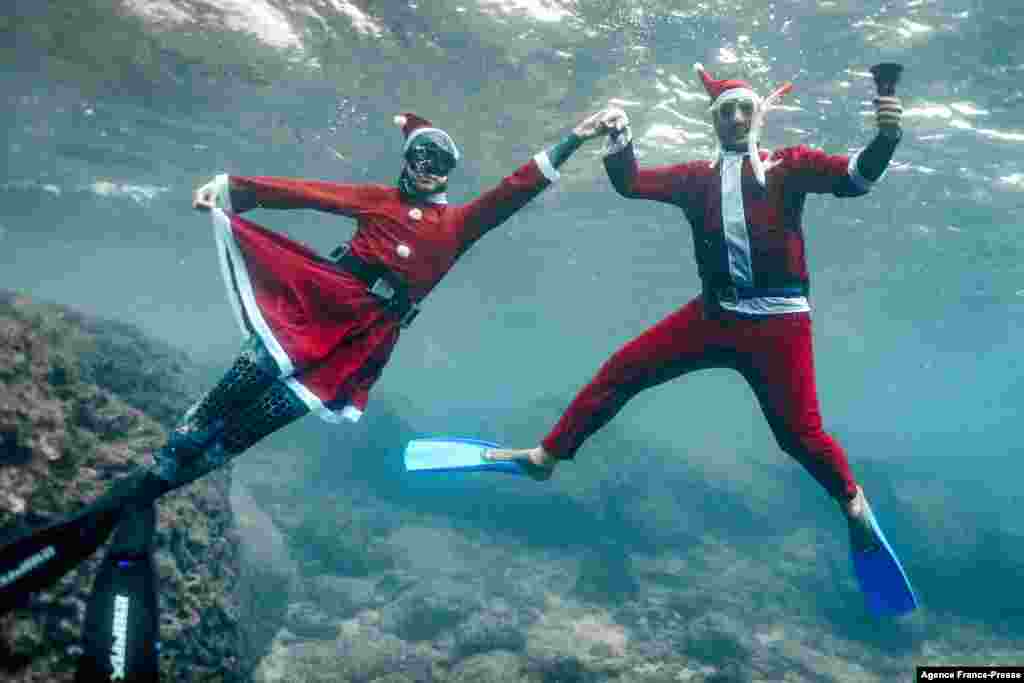 Freedivers dressed in Saint Nicholas (Santa Claus) costumes pose for a picture while submerged under water off the coast of Lebanon&#39;s northern city of Batroun on Christmas eve.