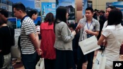Visitors chat as others seek information about the U.S. government's EB-5 visa program at the "Invest in America Summit," a day after an event promoting EB-5 investment in a Kushner Companies development was held, at a hotel in Beijing, May 7, 2017.