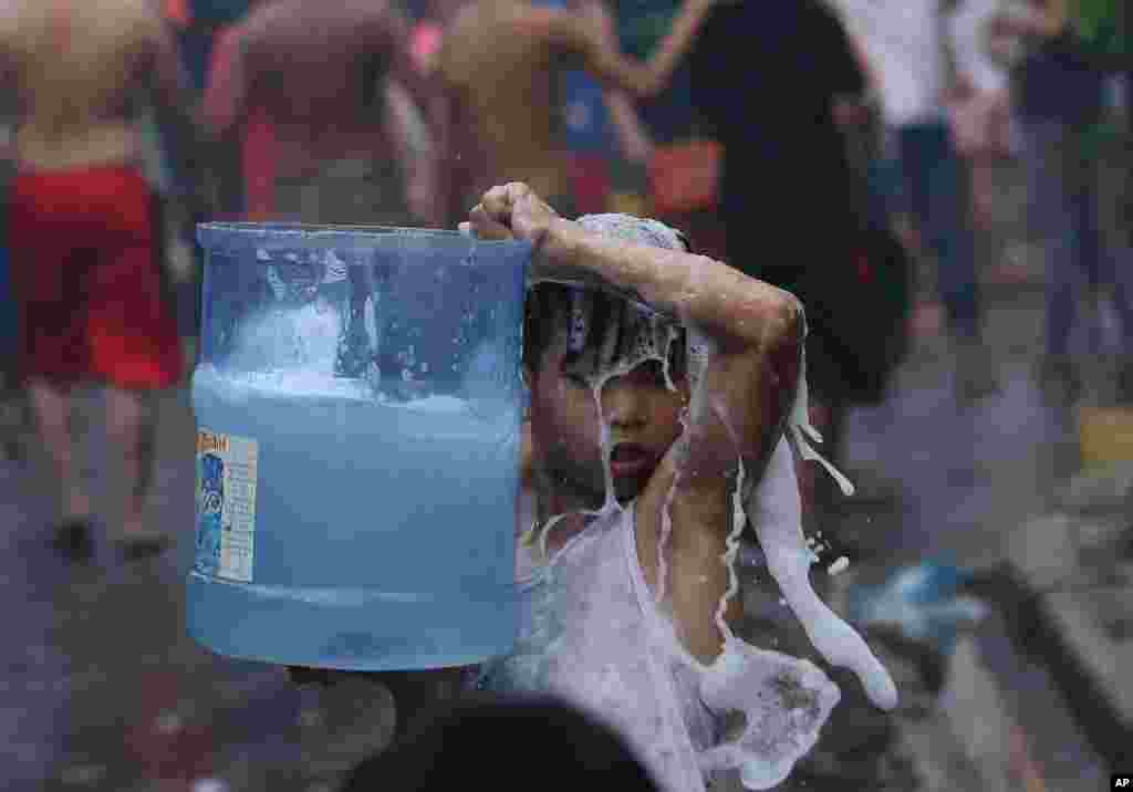 A boy puts out a fire at a residential area in suburban Quezon city, north of Manila, Philippines. The fire destroyed about 300 houses and left at least 600 families homeless, a firefighter said. (AP Photo)