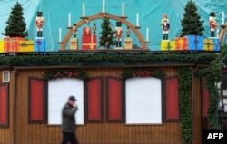 Seorang pria berjalan melewati kios yang dipersiapkan untuk Pasar Natal di Essen, Jerman barat, 29 Oktober 2020, yang tutup akibat merebaknya kembali kasus Covid-19 di kawasan tersebut.
