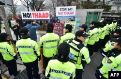 FILE - Police surround anti-war activists holding banners demonstrating against the Terminal High Altitude Area Defense (THAAD) anti-ballistic missile system outside the Foreign Ministry in Seoul, March 17, 2015.